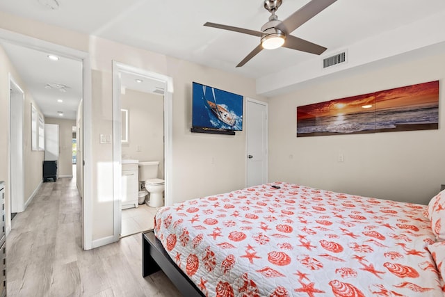 bedroom featuring ceiling fan, ensuite bathroom, and light wood-type flooring