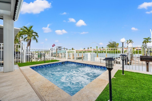 view of pool with a lawn and a water view