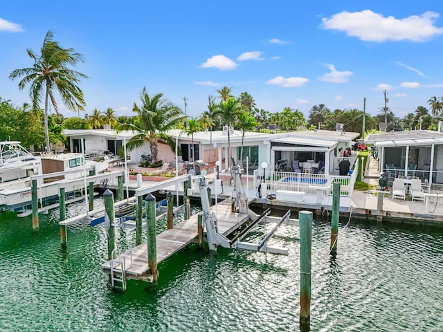 dock area with a water view, a swimming pool, and a patio area