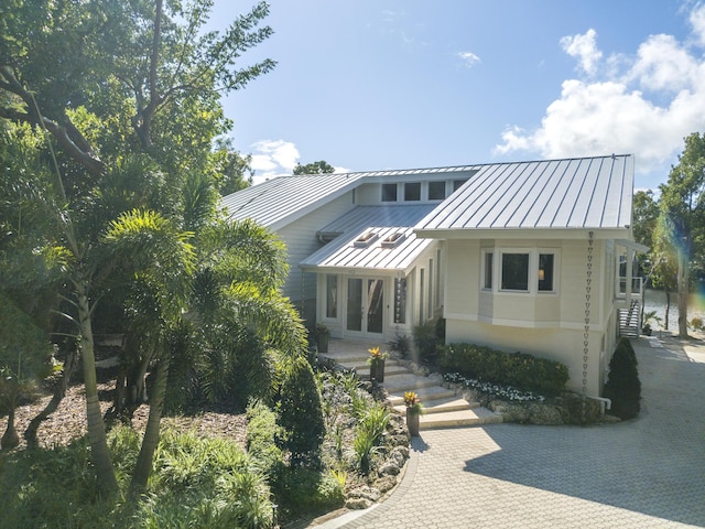 10 Mahogany Ln, Key Largo, FL 33037 - view of front of property with a standing seam roof, a metal roof, stucco siding, and french doors