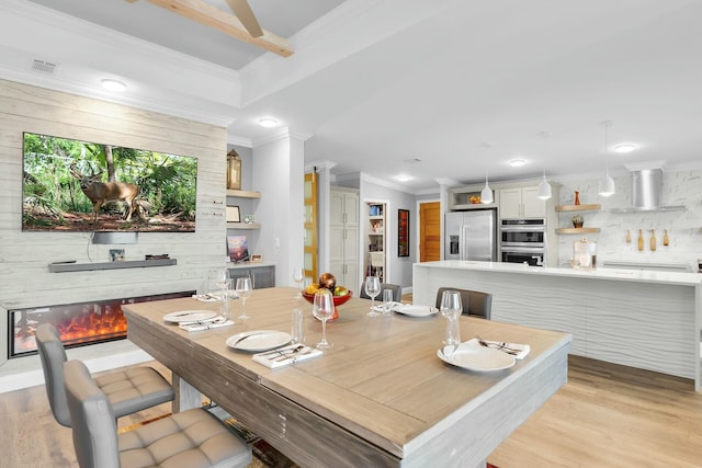 17346 Keystone Rd, Sugarloaf, FL 33042 - dining area with recessed lighting, light wood finished floors, visible vents, crown molding, and a glass covered fireplace