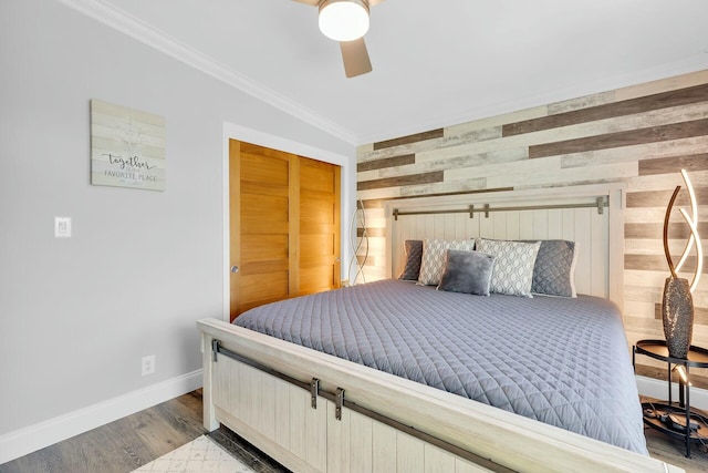 17346 Keystone Rd, Sugarloaf, FL 33042 - bedroom with wooden walls, wood finished floors, an accent wall, crown molding, and baseboards
