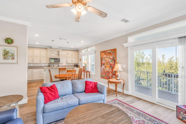 living room with visible vents, light wood-style flooring, and ornamental molding