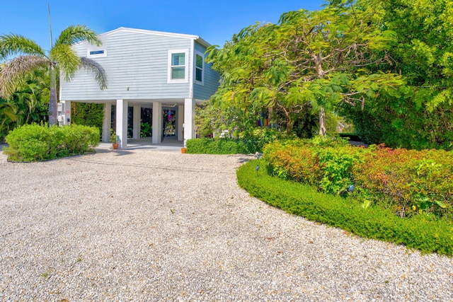 back of house featuring a carport and driveway