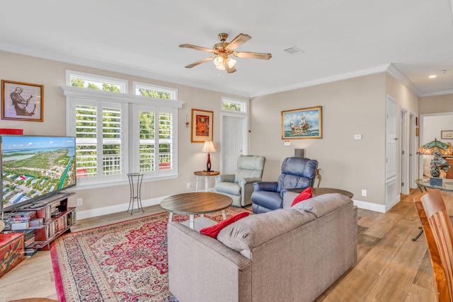 living room featuring visible vents, a ceiling fan, light wood-style floors, crown molding, and baseboards