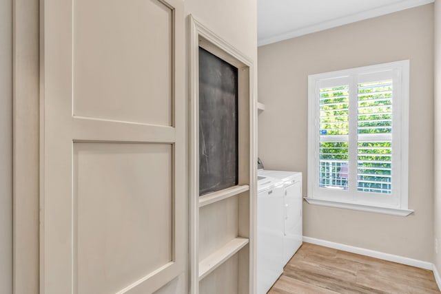 laundry room featuring baseboards, laundry area, light wood-style floors, washer and dryer, and crown molding