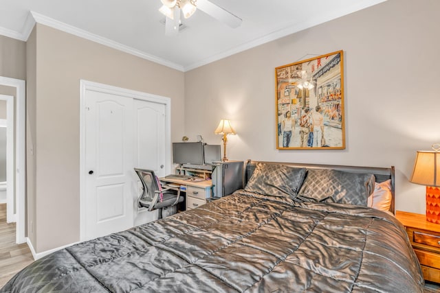 bedroom with a ceiling fan, crown molding, wood finished floors, and a closet