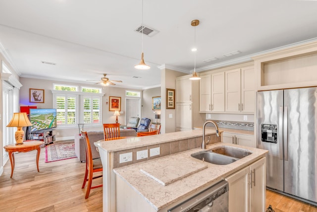 kitchen featuring visible vents, crown molding, light wood-style flooring, appliances with stainless steel finishes, and a sink