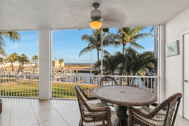 balcony featuring a water view and ceiling fan