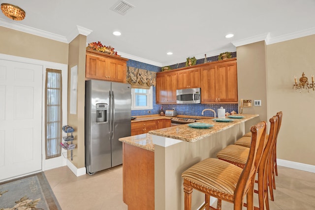 kitchen featuring stainless steel appliances, crown molding, light stone counters, and kitchen peninsula