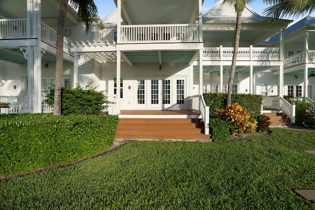 rear view of house featuring a yard, a pergola, and french doors