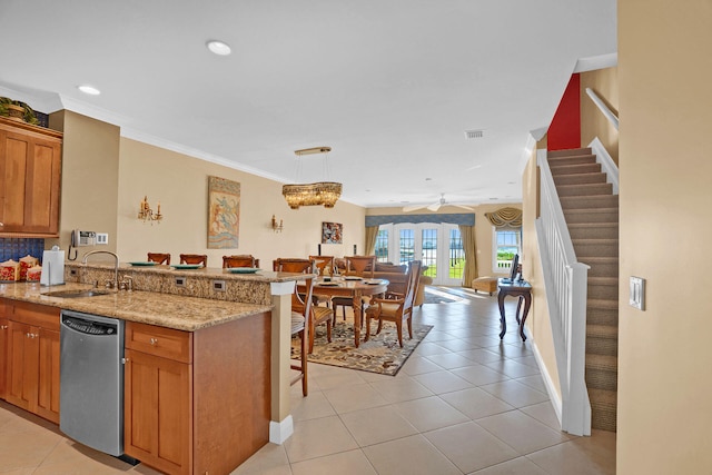 kitchen featuring a breakfast bar, decorative light fixtures, sink, stainless steel dishwasher, and kitchen peninsula