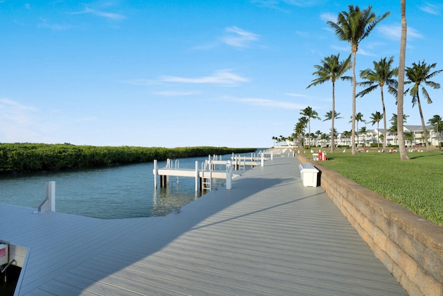 view of dock with a water view and a yard