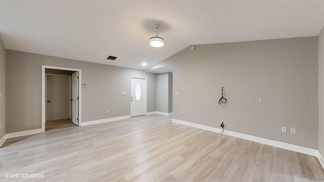 empty room featuring lofted ceiling and light hardwood / wood-style floors