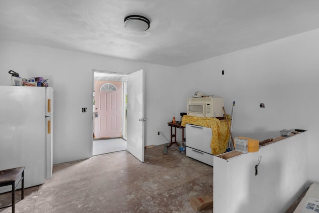 kitchen with white appliances and concrete floors