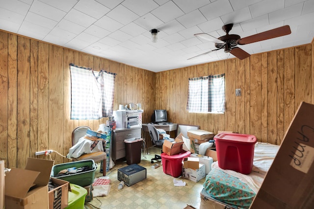 misc room with wooden walls and ceiling fan