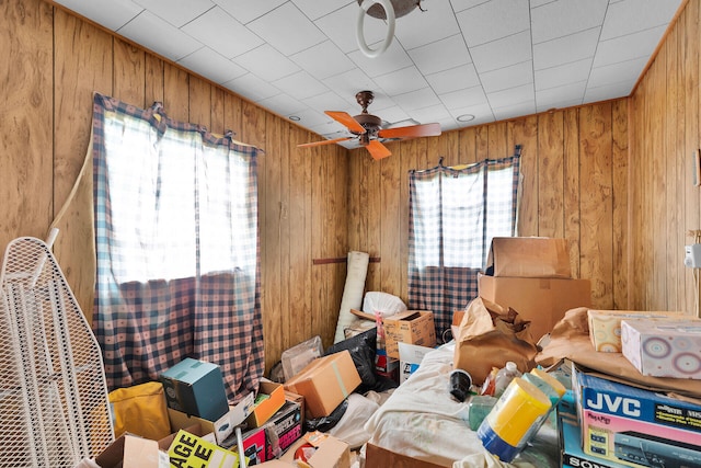 miscellaneous room featuring ceiling fan and wood walls