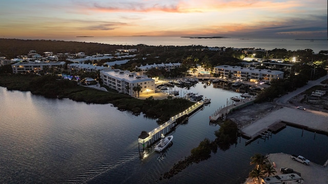 aerial view at dusk featuring a water view