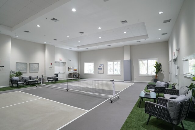 game room featuring a towering ceiling and a raised ceiling