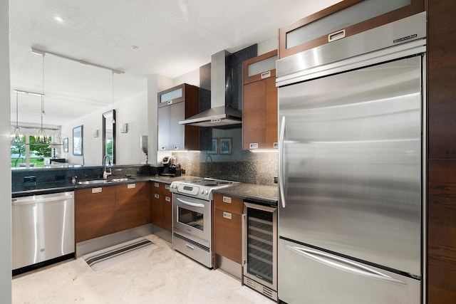 kitchen with appliances with stainless steel finishes, decorative light fixtures, sink, beverage cooler, and wall chimney range hood