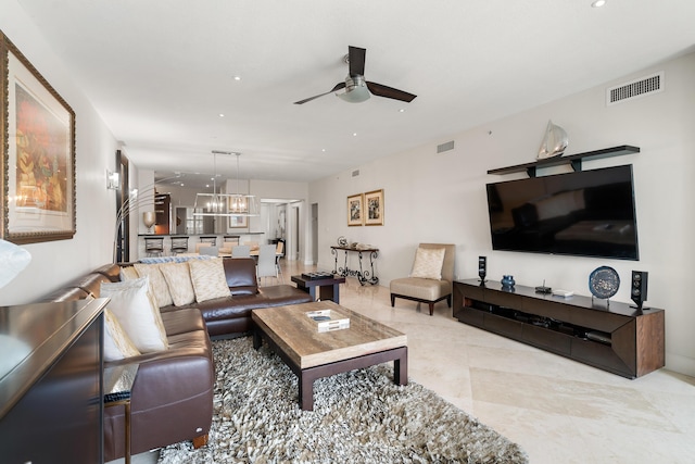 living room with ceiling fan with notable chandelier