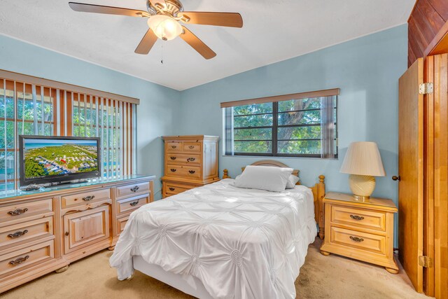 bedroom featuring light colored carpet and ceiling fan