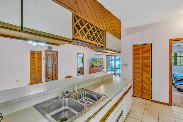 kitchen featuring white cabinetry, sink, and light tile patterned flooring