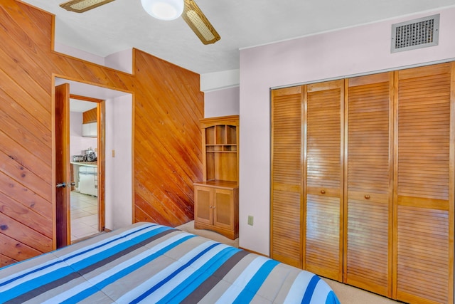 unfurnished bedroom featuring a closet, ceiling fan, and wood walls