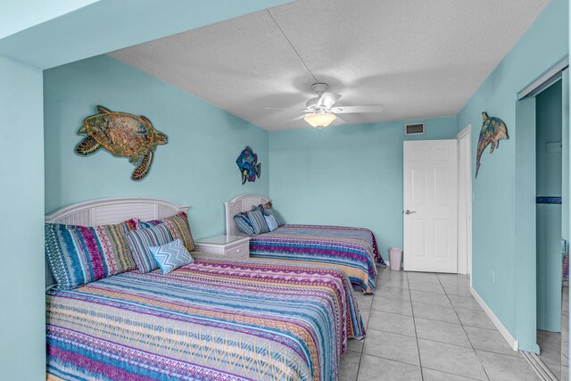 bedroom with ceiling fan, a textured ceiling, and light tile patterned flooring