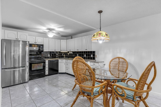 kitchen featuring white cabinets, decorative light fixtures, decorative backsplash, and black appliances