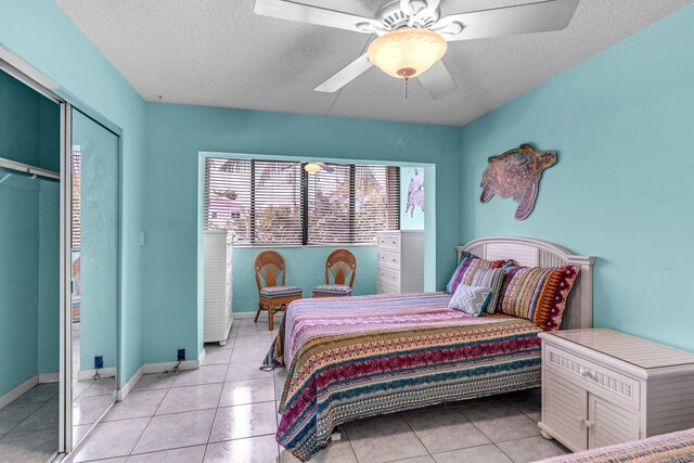 tiled bedroom featuring ceiling fan, a textured ceiling, and a closet