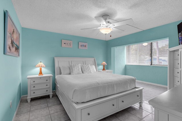 tiled bedroom with ceiling fan and a textured ceiling