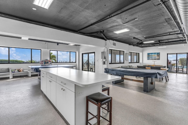 kitchen with white cabinetry, a center island, and billiards