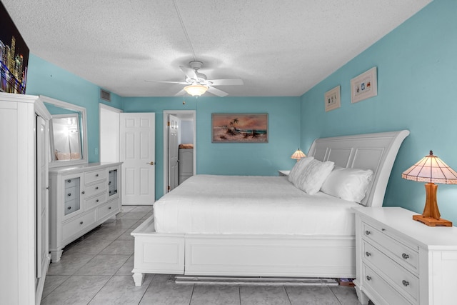 tiled bedroom with ceiling fan and a textured ceiling