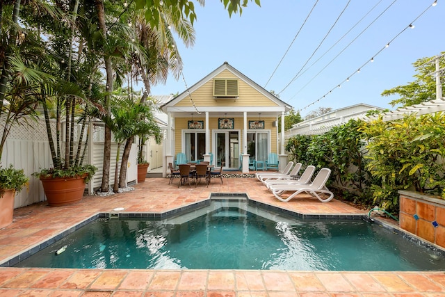 rear view of house with a fenced in pool, a patio, and an outdoor structure