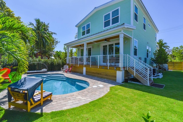 back of house featuring a fenced in pool, a lawn, stairway, a ceiling fan, and a fenced backyard