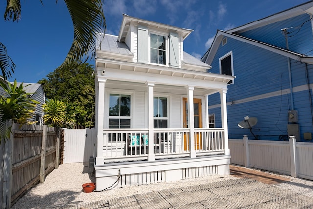 view of front of property featuring a porch and fence