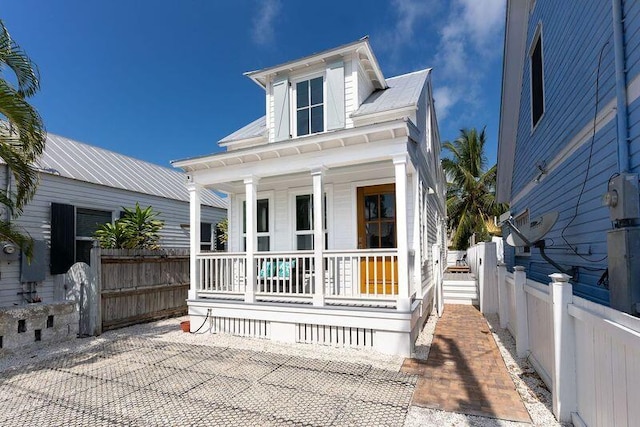 view of front of home with a porch and fence