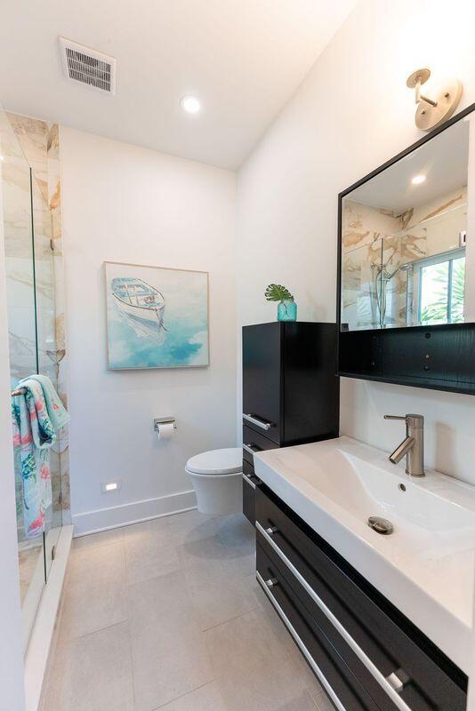 bathroom featuring vanity, baseboards, visible vents, a stall shower, and toilet