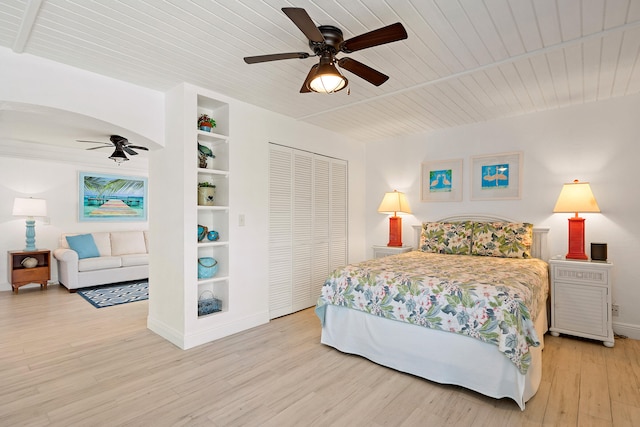 bedroom featuring wood ceiling, light hardwood / wood-style floors, a closet, and ceiling fan