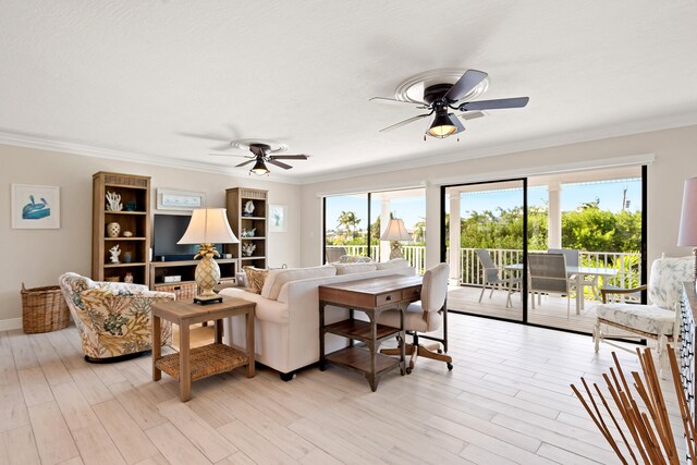 living room featuring ceiling fan with notable chandelier, light hardwood / wood-style flooring, and ornamental molding