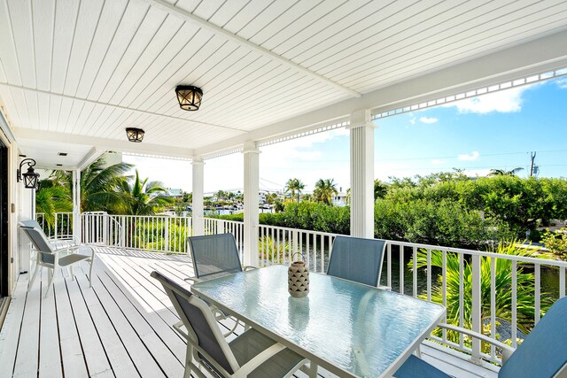 back of property featuring a water view, a sunroom, and a patio area