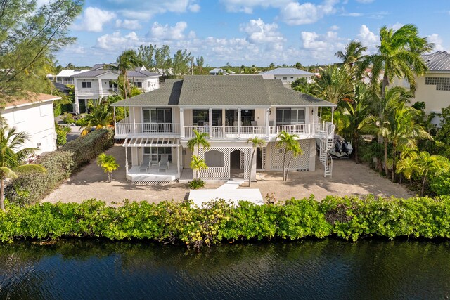 rear view of house with a patio area and a water view