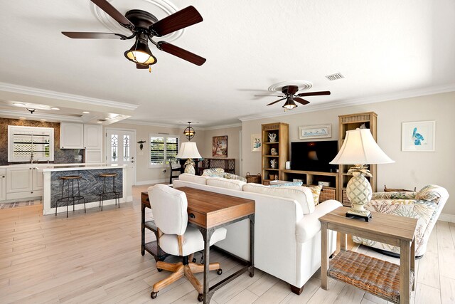 kitchen with sink, ornamental molding, stainless steel appliances, and white cabinets