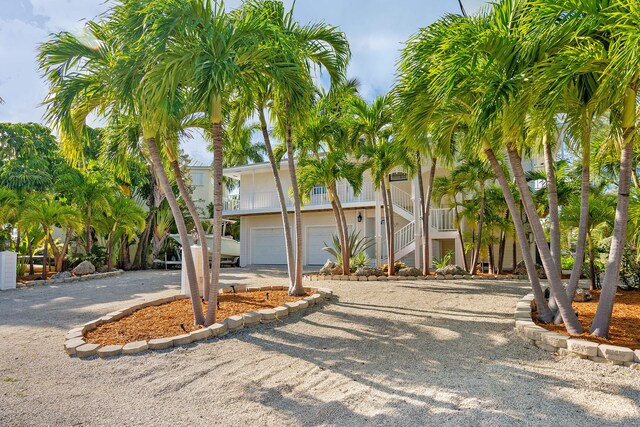 back of property with a patio area, a carport, and a water view