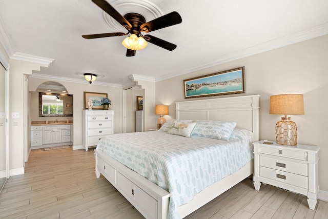 bedroom with connected bathroom, crown molding, and light hardwood / wood-style floors