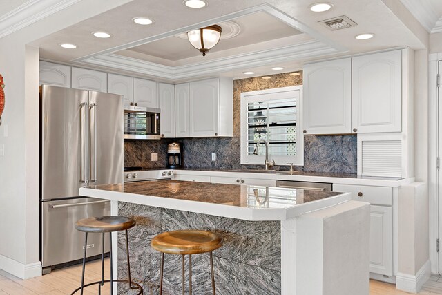 kitchen with white cabinetry, stainless steel appliances, and a center island