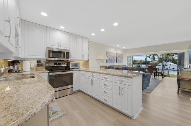 18 Anchor Dr Unit B, Key Largo, FL 33037 - kitchen with a sink, open floor plan, light wood-type flooring, stainless steel appliances, and a peninsula