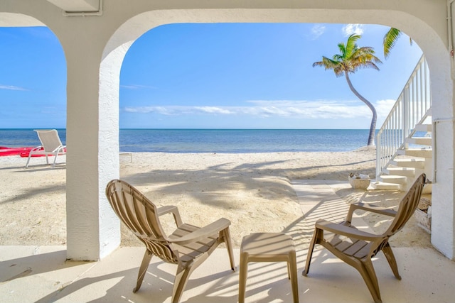 exterior space featuring a water view and a beach view