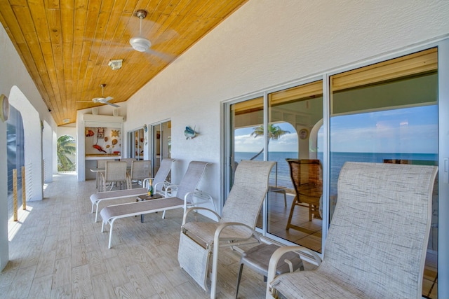 view of patio with a water view and ceiling fan